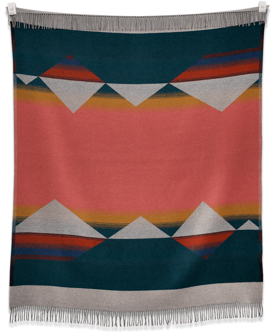 A colorful Mountain Tropic blanket hanging on a wall by Sackcloth & Ashes.