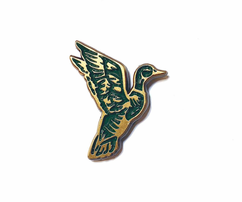 A Mallard Duck enamel pin by The Wild Wander with a bird on it.