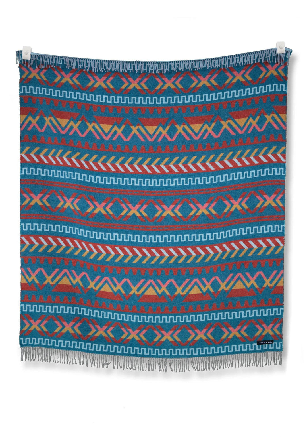 A Ridgeline Sierras blanket hanging on a wall, made by Sackcloth & Ashes.